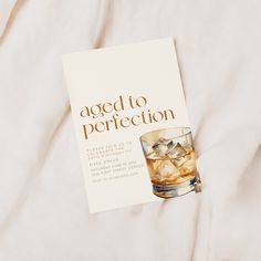 a book with an image of a glass of whiskey on it and the title aged to perfection written in gold