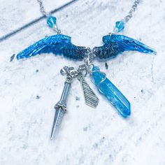 This necklace features two resin wings with back and bright shiny blue. I used a quartz crystal in sky blue because I think of blue with Cass.. I also feature his sword charm with his trademark tie. I used to light blue crystals on top. You will not get the one in the photo, however yours will look as close as possible to the one in the photo. The crystal could be bigger or smaller depending on what's in stock. If you would like to see a photo of your personally made necklace before it sends jus Light Blue Crystals, Bff Necklaces, Acrylic Charms, Wedding Jewellery Necklace, Castiel, Gorgeous Necklaces, Diy Necklace, Blue Crystals, Wedding Necklace