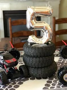 a table topped with monster trucks and balloons