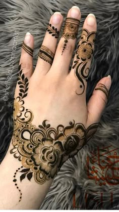 a woman's hand with henna tattoos on it