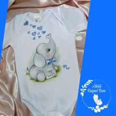 a white baby bodysuit with an elephant on it's chest and hearts coming out of its back