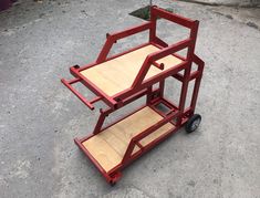 a red cart sitting on top of a cement ground