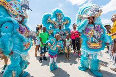 some people are dressed up and standing in front of some blue dragon costumed characters