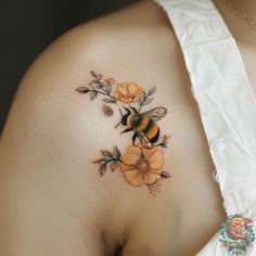 a woman with a bee and flowers tattoo on her chest