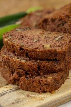 two slices of chocolate zucchini bread on a cutting board with green beans in the background