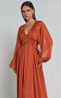 Step out in style and turn heads wherever you go with our stunning Roxanna Maxi Dress! This gorgeous A-line dress features a flattering ruched waist that cinches in your figure, giving you an effortlessly chic look. Made from luxurious georgette polyester fabric, this rust-colored beauty is perfect for any occasion - be it a party day or a special night out. The long sleeves add an elegant touch while the plunging neckline adds a hint of allure. Embrace your unique style and radiate confidence w Europe Dresses, Empire Line Dress, Ruched Waist Dress, Bridesmaid Dresses With Sleeves, Radiate Confidence, Baby Shower Dresses, Empire Waist Dress, Bell Sleeve Dress, Long Sleeve Maxi