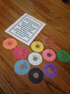 a wooden table topped with lots of doughnuts on top of paper next to a note