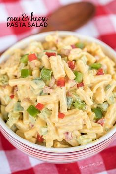 a bowl filled with macaroni salad on top of a red and white checkered table