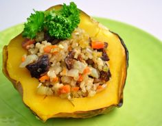 a stuffed acorn with rice and vegetables on a green plate, ready to be eaten