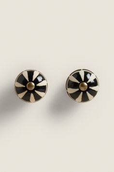 pair of black and white earrings with gold accents on the front, back and sides