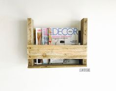 a wooden shelf with magazines and magazines on it's sides, mounted to the wall