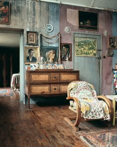 a living room filled with furniture and pictures on the wall next to a wooden floor