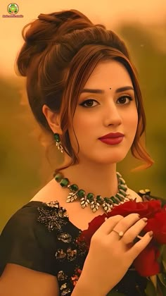 a woman in a black dress holding a red rose and wearing an elaborate necklace with jewels on her neck