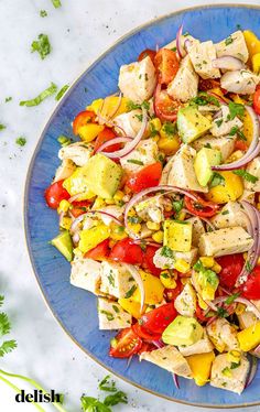 a blue plate topped with chicken and veggies on top of a white table