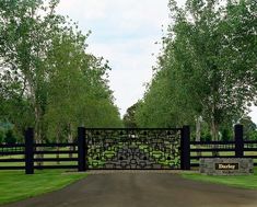 a gated entrance to a park with trees in the background