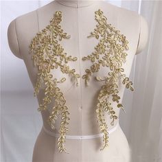 the back of a mannequin with gold sequins and leaves on it