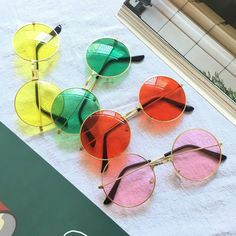 four pairs of colorful sunglasses sitting on top of a white towel next to a window