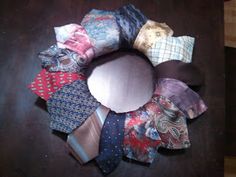 a bunch of ties are arranged in a circle on a wooden table with a black surface