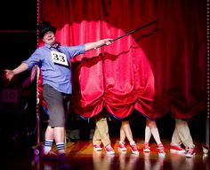 a man standing on top of a stage holding a stick