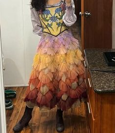 a woman is taking a selfie in the mirror wearing a colorful dress and boots