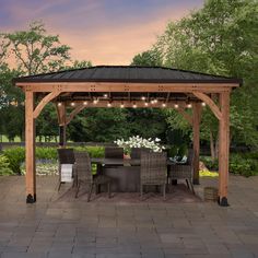 a wooden gazebo sitting on top of a patio next to a table and chairs