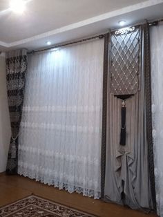 a living room with curtains and rugs on the floor