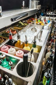 a kitchen filled with lots of different types of drinks and condiments on the counter