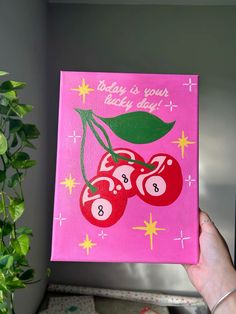 a hand holding up a pink card with two cherries on it and the words baby is