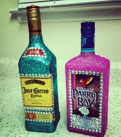 two bottles of liquor sitting on top of a counter