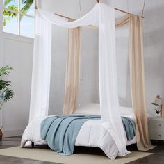 a canopy bed with white and beige drapes on it's sides in a bedroom