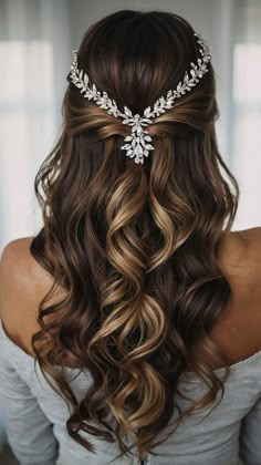 the back of a woman's head with long wavy hair and a tiara