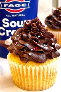 two cupcakes with chocolate frosting and sprinkles are on a plate