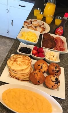 the breakfast is ready to be eaten on the kitchen counter with eggs, fruit, and muffins