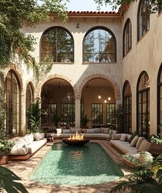 an outdoor living area with couches and a fire pit in the middle of it