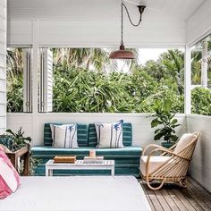 a bed sitting on top of a wooden floor next to a white couch and table