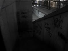 an alley with graffiti on the walls and below it is a cityscape at night