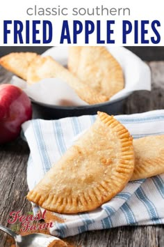 two apple pies sitting on top of a blue and white towel next to an apple