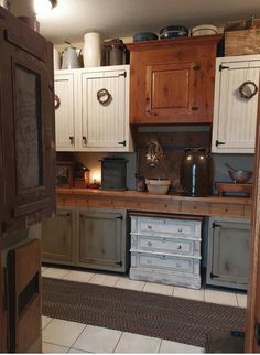 an old fashioned kitchen with lots of cupboards and drawers on the wall, along with white tile flooring