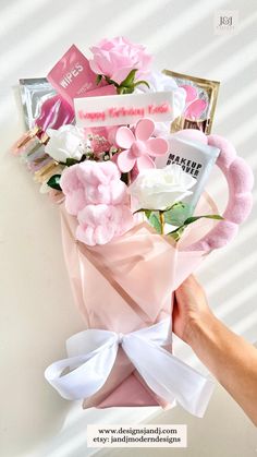 someone is holding a bouquet of flowers with pink and white blooms in it's wrap