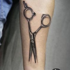 a pair of scissors tattoo on the arm