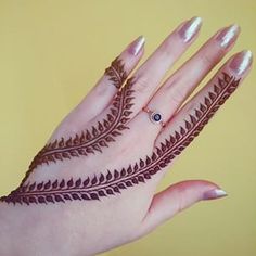 a woman's hand with henna tattoos on it