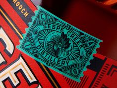 a close up of a label on a red and green beverage bottle with the word despered gallery printed on it