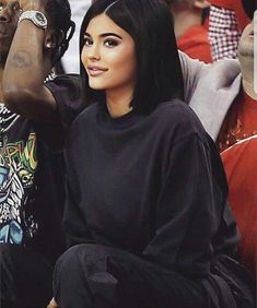 a woman sitting next to a man at a basketball game