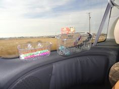 the interior of a car with plastic containers in the passenger seat and on the dashboard