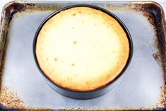 a pan filled with food sitting on top of a metal tray next to a white table cloth