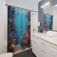 a bathroom with a shower curtain that has an underwater scene on it