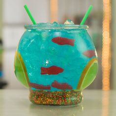 a glass filled with liquid and fish on top of a table