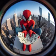 a spider man sitting on top of a building holding money