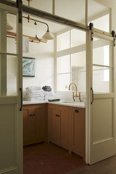 an open door leading into a kitchen with lots of towels on the counter and cabinets