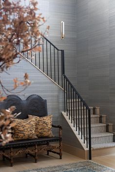 a living room with a couch and some pillows on the floor next to a stair case